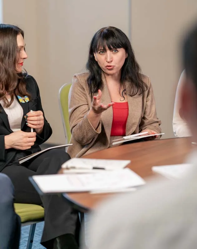 A woman sat at a table deep in a focus group discussion 