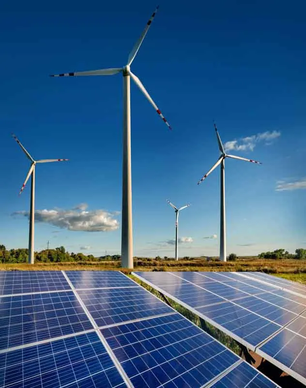 Wind turbines on a field with solar panels in the foreground