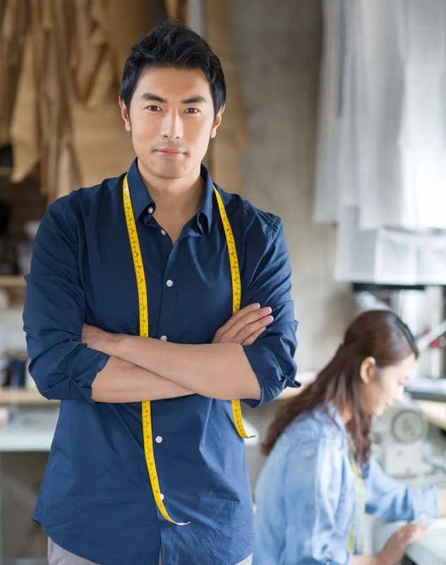 Man with tape measure around his neck standing in a workshop