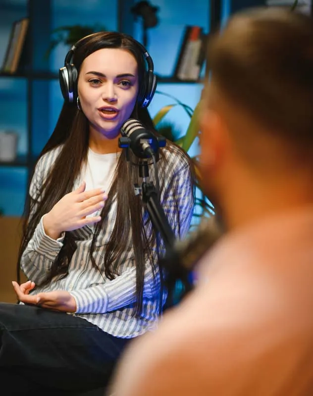 Man and woman talking in a podcast recording studio 