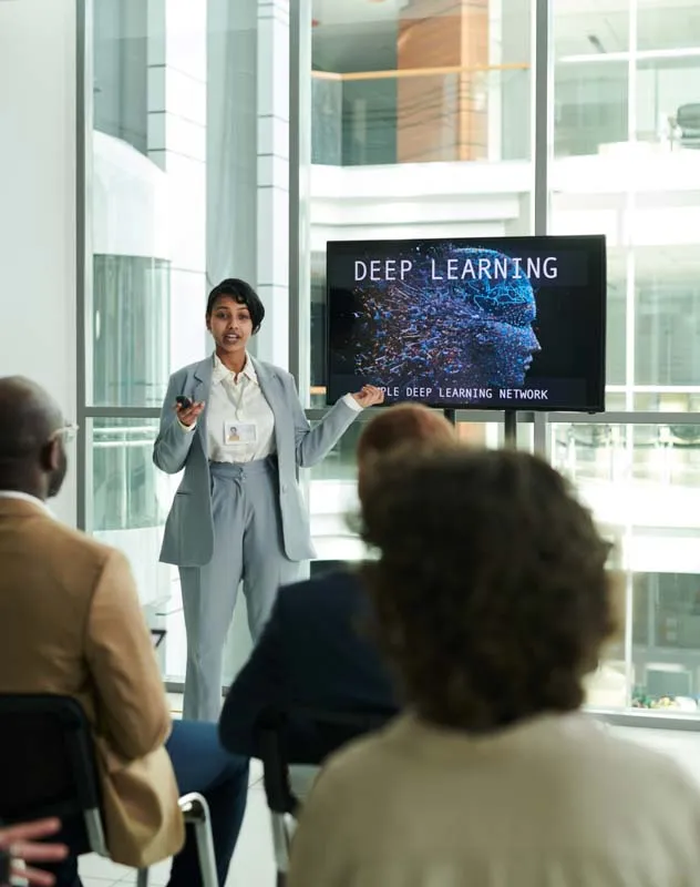 A female professional presenting to a group of people sat in front of her