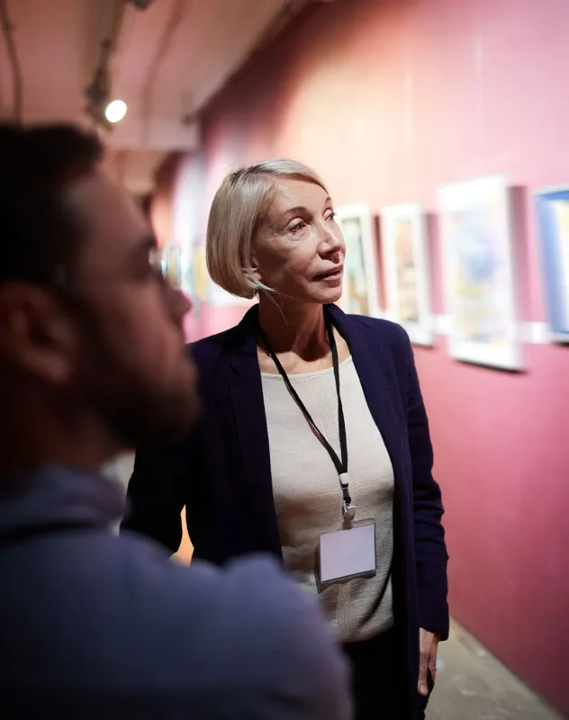 Two people looking at a display of creative images at a showcase event