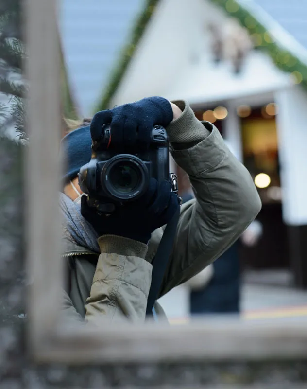 Mirror view of a man discreetly filming with a DSLR camera 