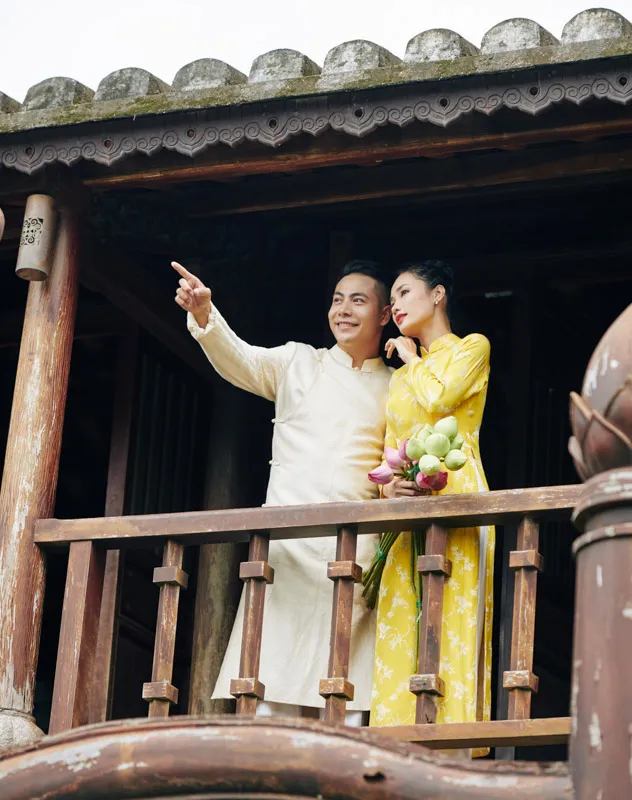 Buddhist couple standing on a balcony following their wedding ceremony
