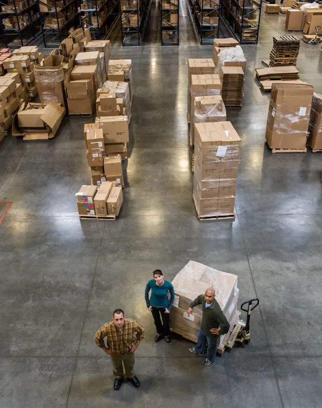 A group of people inside a warehouse looking up at a drone