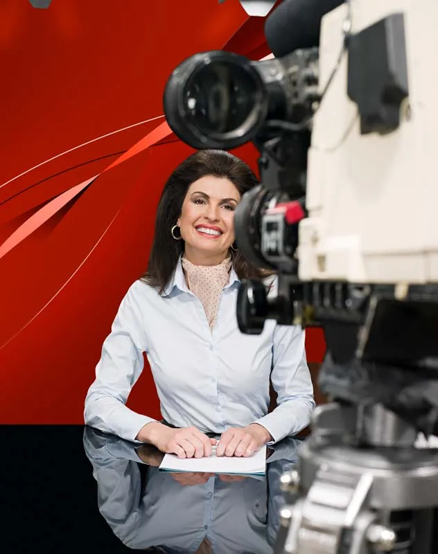 Woman in front of a camera reading from an autocue teleprompter 
