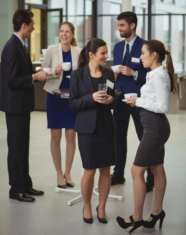 A group of people standing and networking at a corporate event 