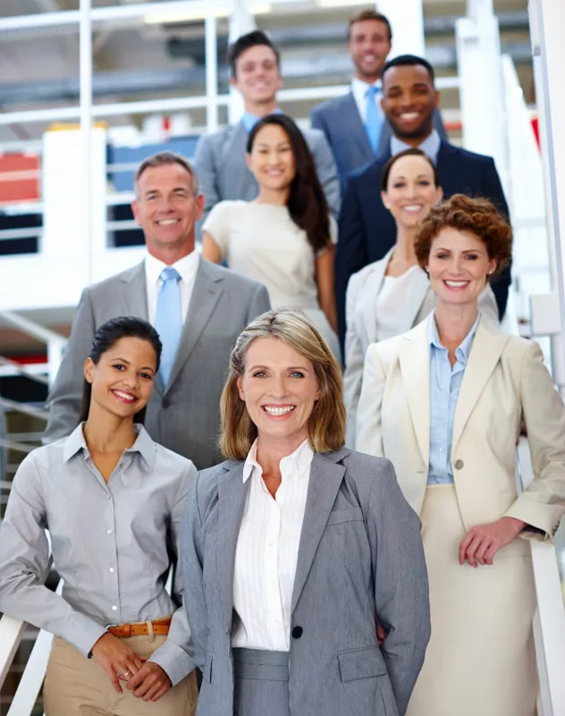 A group of employees standing together on the stairs in an office
