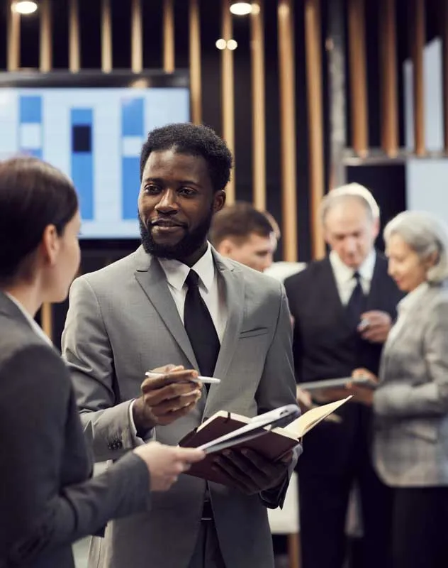A professional looking man talking to a colleague at a conference