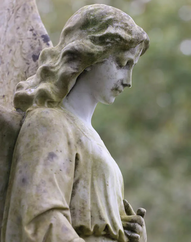 An ageing religious statue in a graveyard