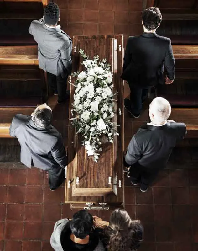 Overhead view of several pallbears carrying a coffin into church