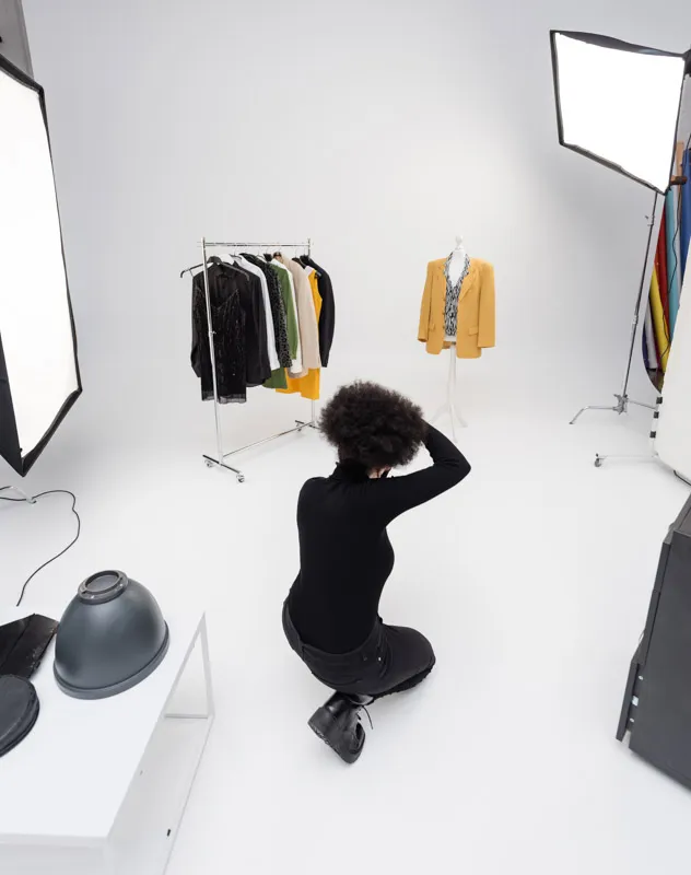 A female photographer taking pictures of garments in an infinity cove studio