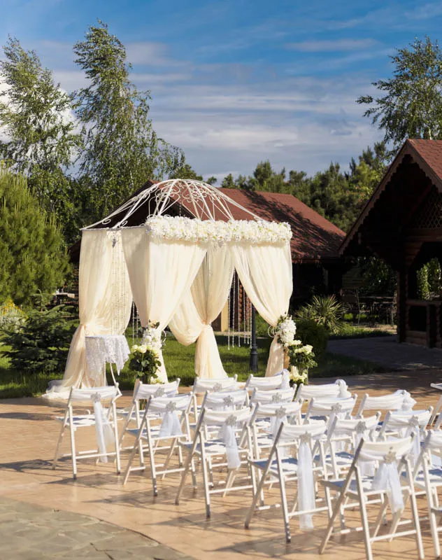 A Jewish chuppah with drapes and chairs awaiting a traditional jewish wedding ceremony