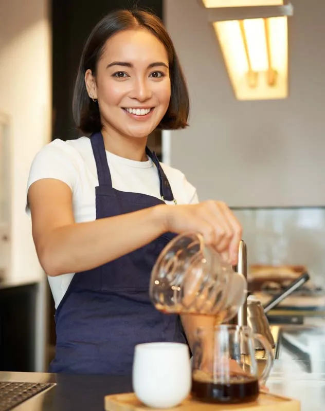 An attractive woman dressed in a blue overall promoting a coffee product