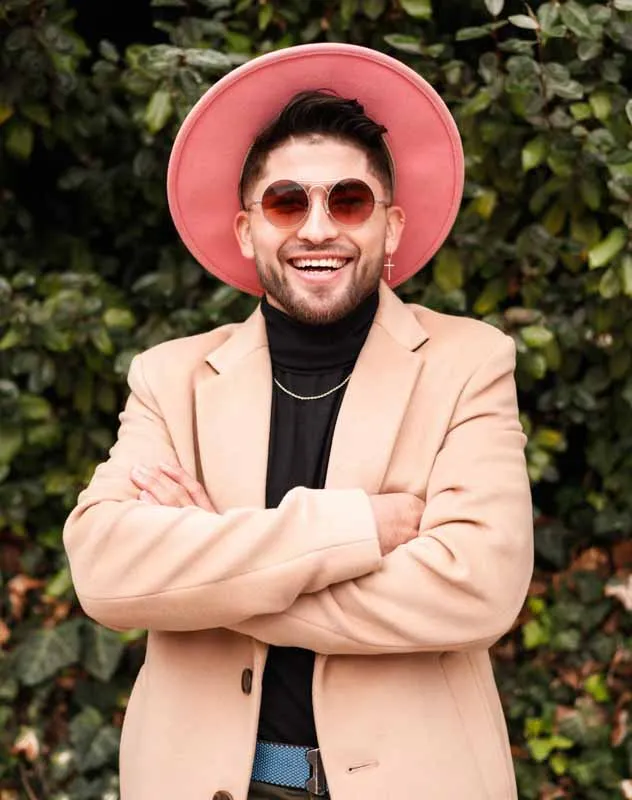A social influencer wearing a peach coloured outfit talking in front of a camera