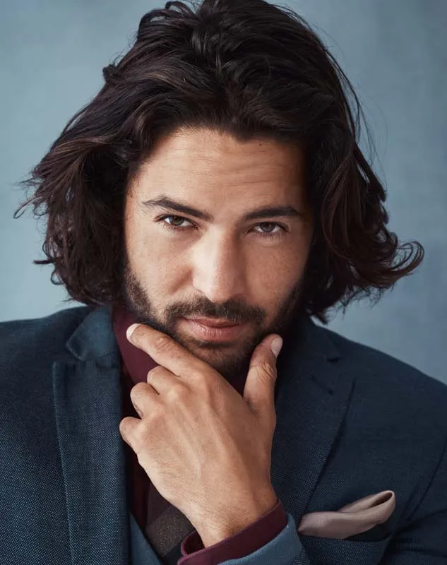 An attractive male actor looking pensively into the camera