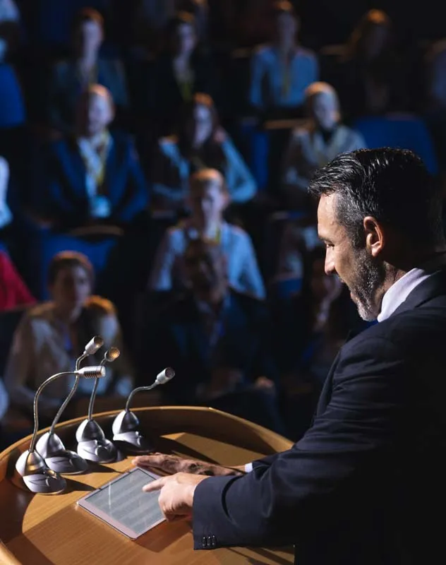 Man standing at the podium announcing winner at an awards show