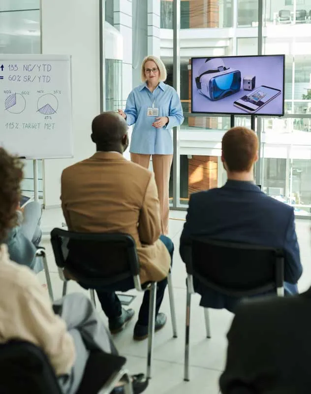 A woman presenting a new product to a group of people at a showcase event