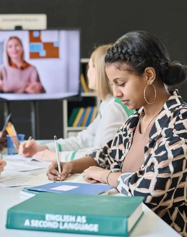 Two people sat at desks taking notes during a webinar