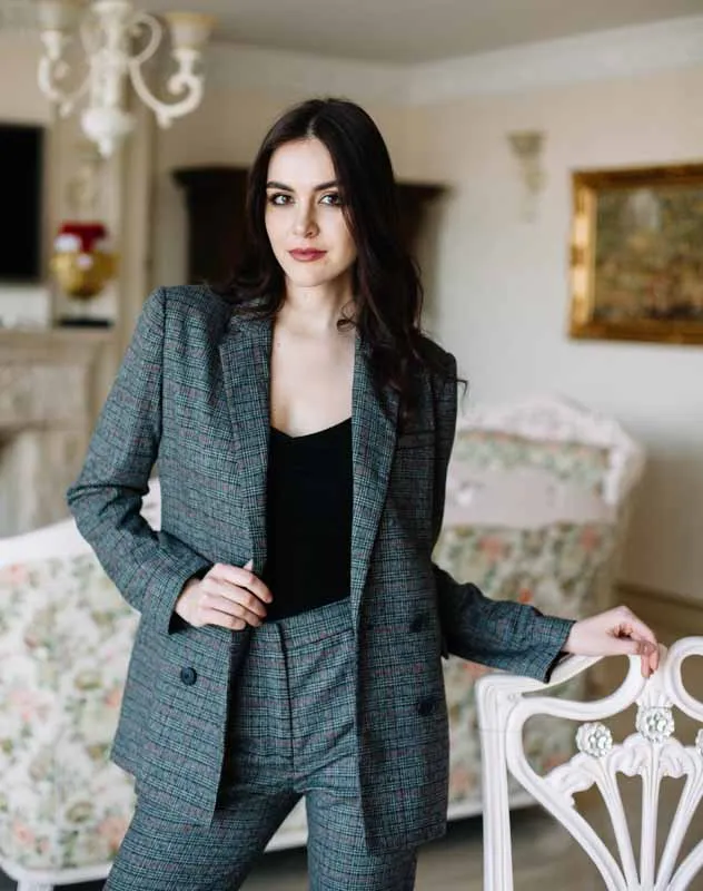 A smartly dressed female influencer standing in front of the video camera