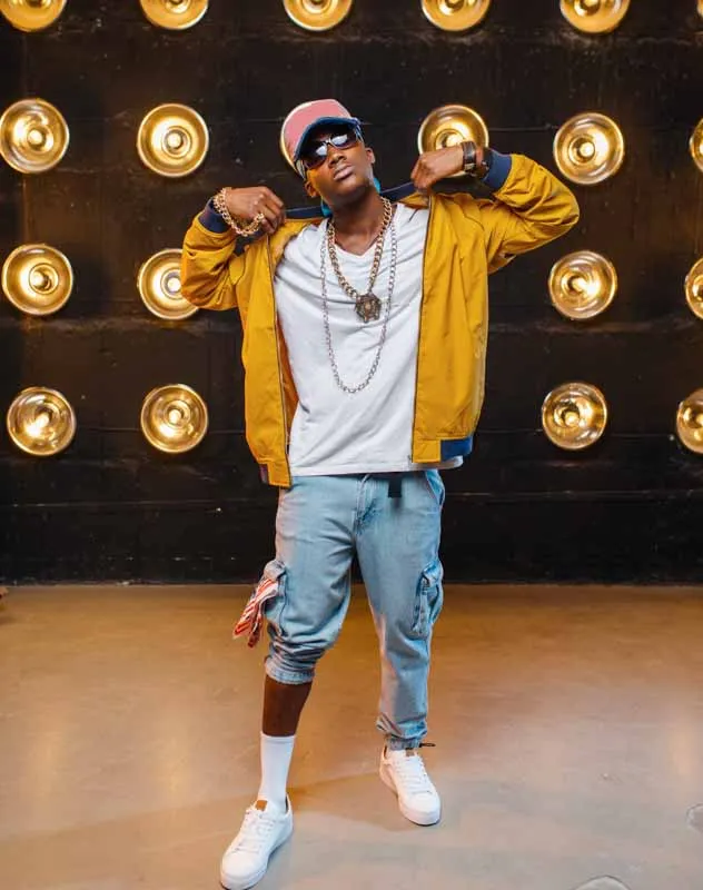 Creatively dressed male influencer standing with lights in the background