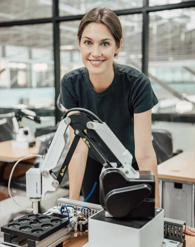 A technician in a laboratory smiling towards the camera