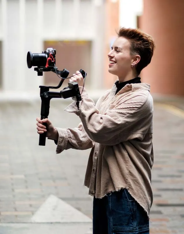 A videographer with camera on a gimbal creating content