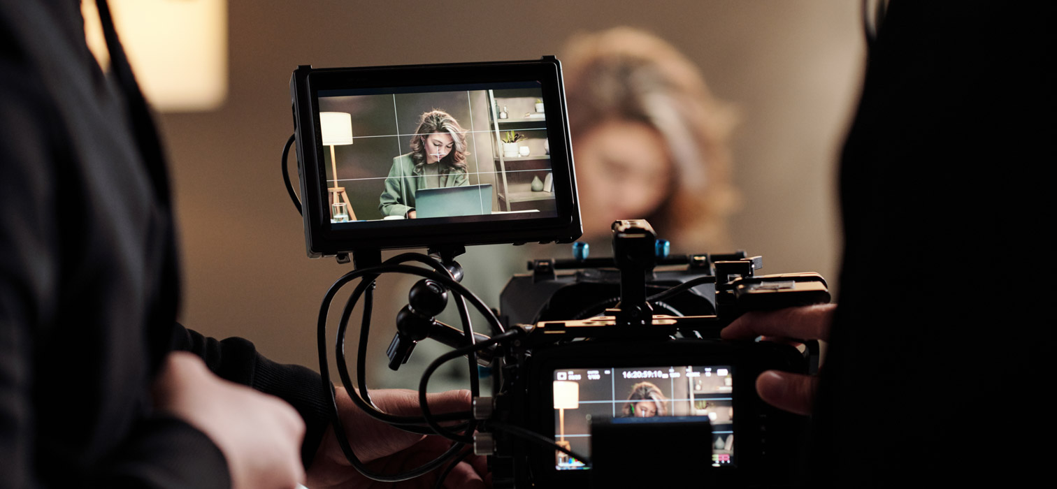 Rear view of a woman in a yellow top smiling into a video camera