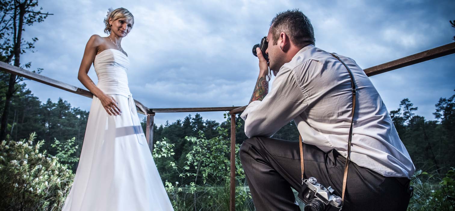 Behind the camera view of a bride getting ready as she is filmed by a wedding videographer 