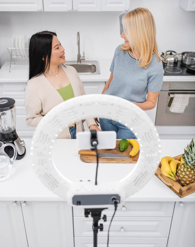 Two women in a kitchen talking as part of their content creation project