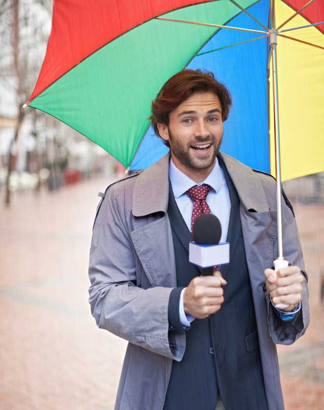 Man with a colourful umbrella standing in the street interviewing people
