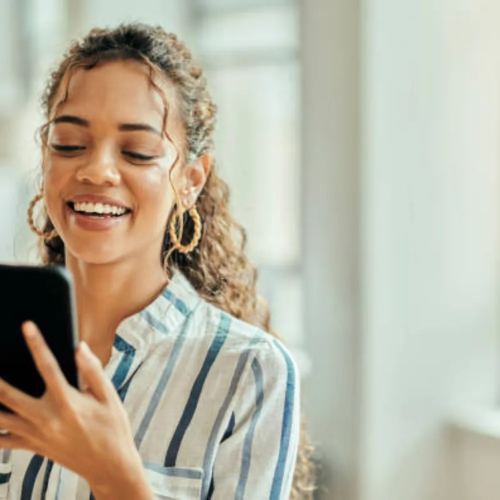 A smiling woman on the phone calling to make a reservation
