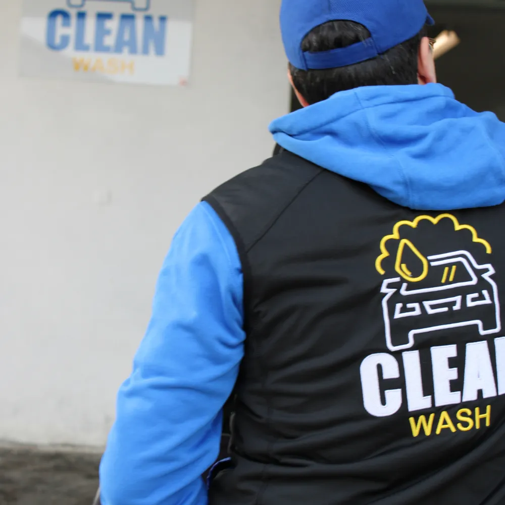 An employee with CleanWashAuto on his back
