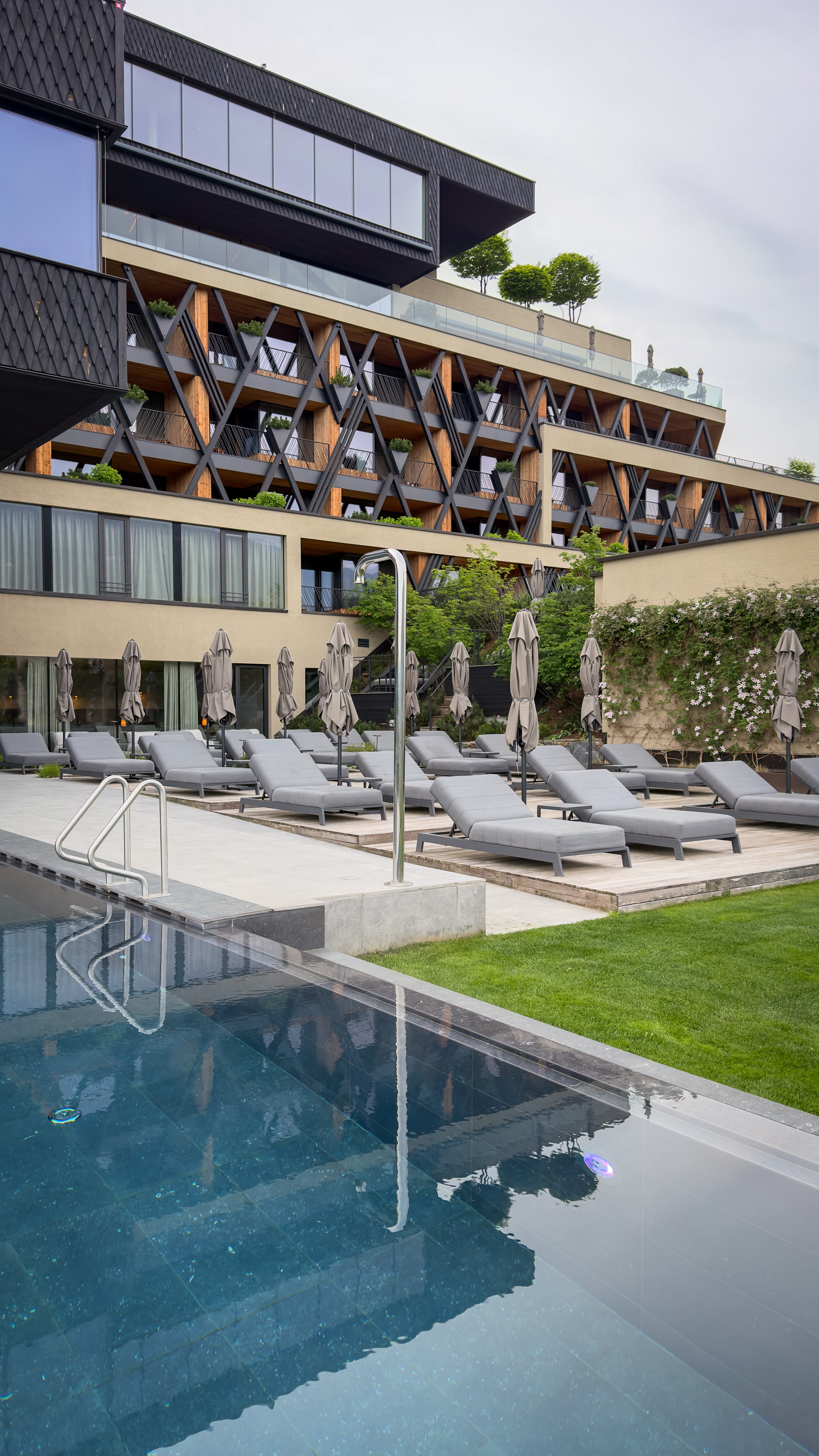 Pool and hotel front view with sunbeds