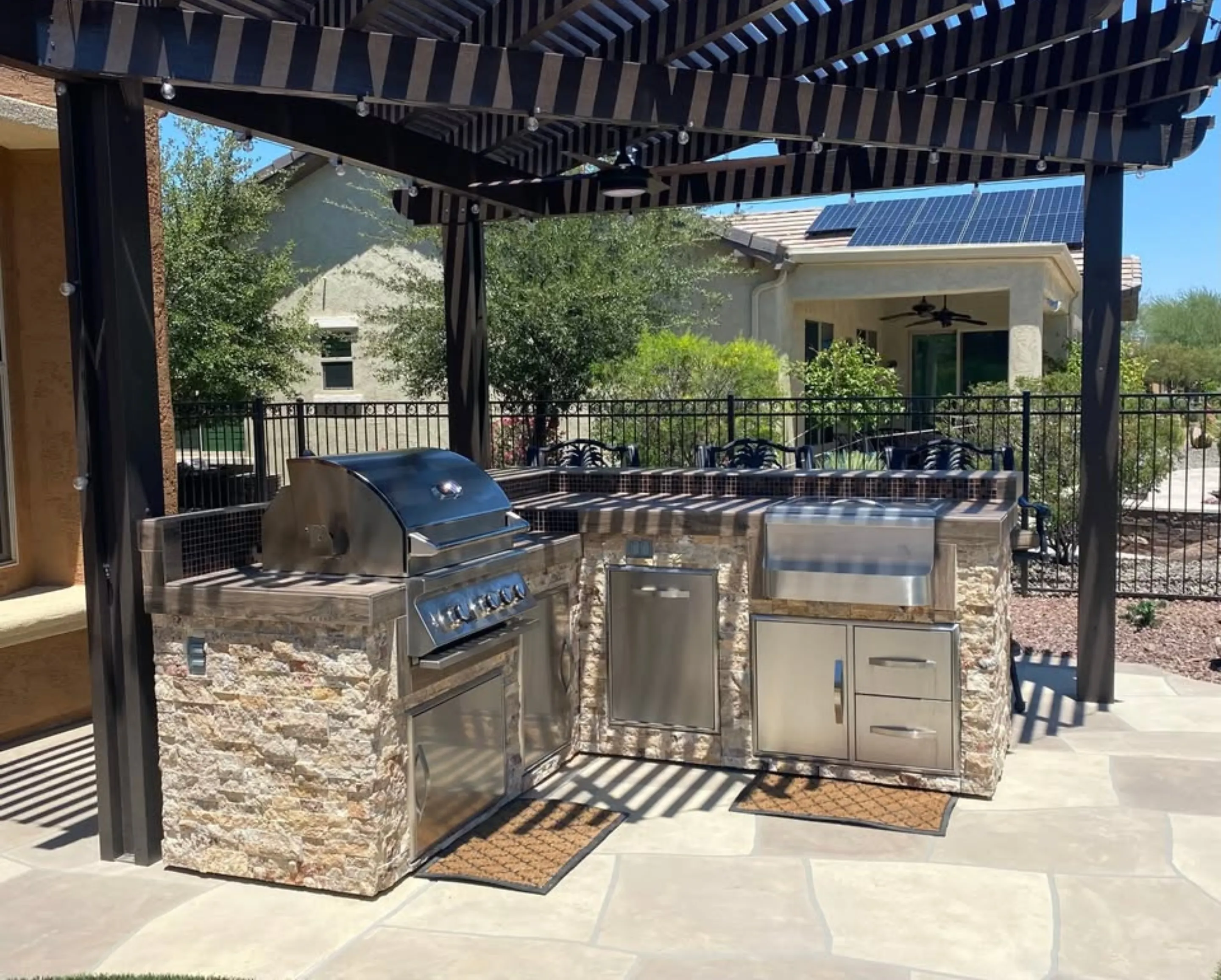 Custom outdoor kitchen with built-in grill and pergola by Red Rock Outdoor Living
