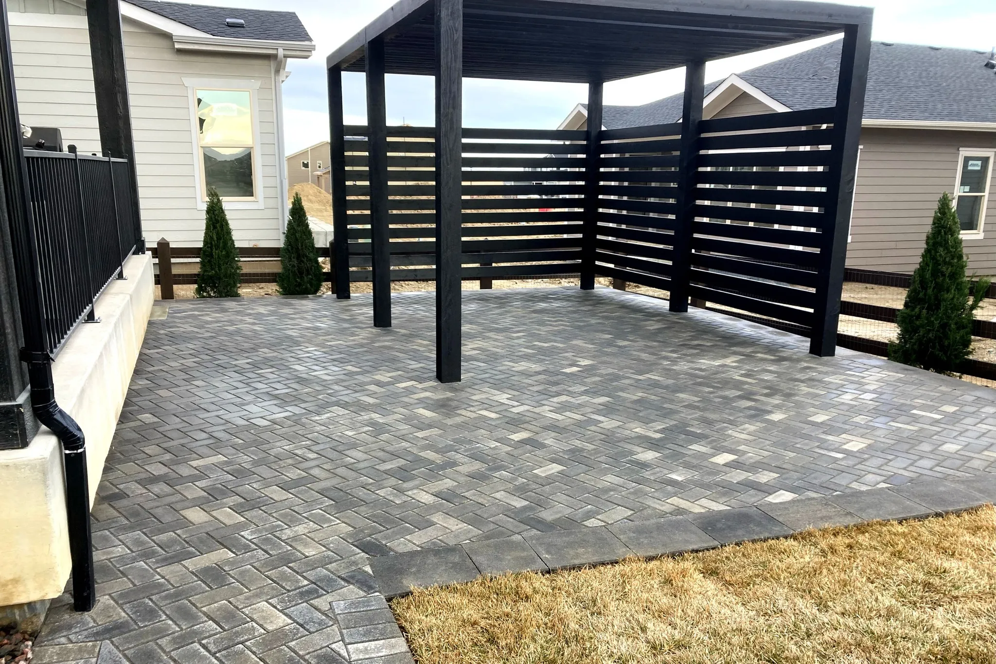 Custom paver patio with modern pergola for a backyard