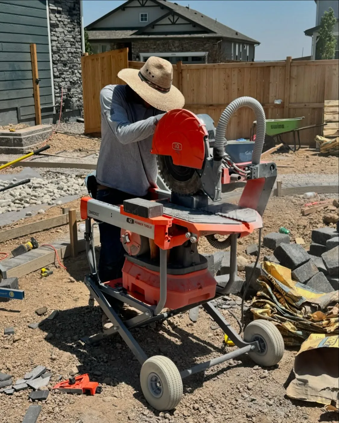Landscape contractor cutting pavers during a hardscape installation