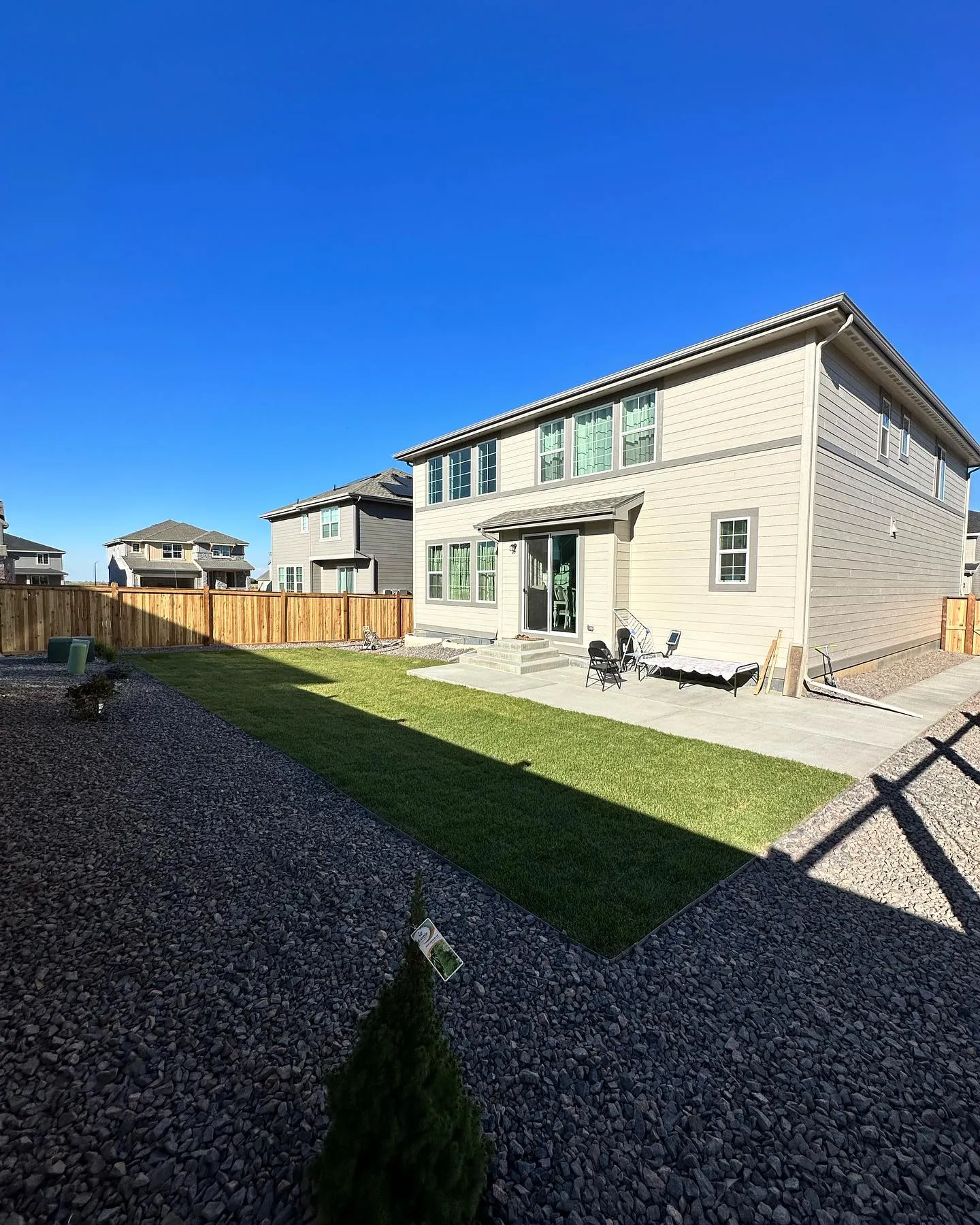 Finished backyard landscaping with new sod and decorative rock for a Colorado home