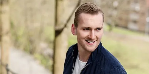 Bilde av smilende mann utendørs.