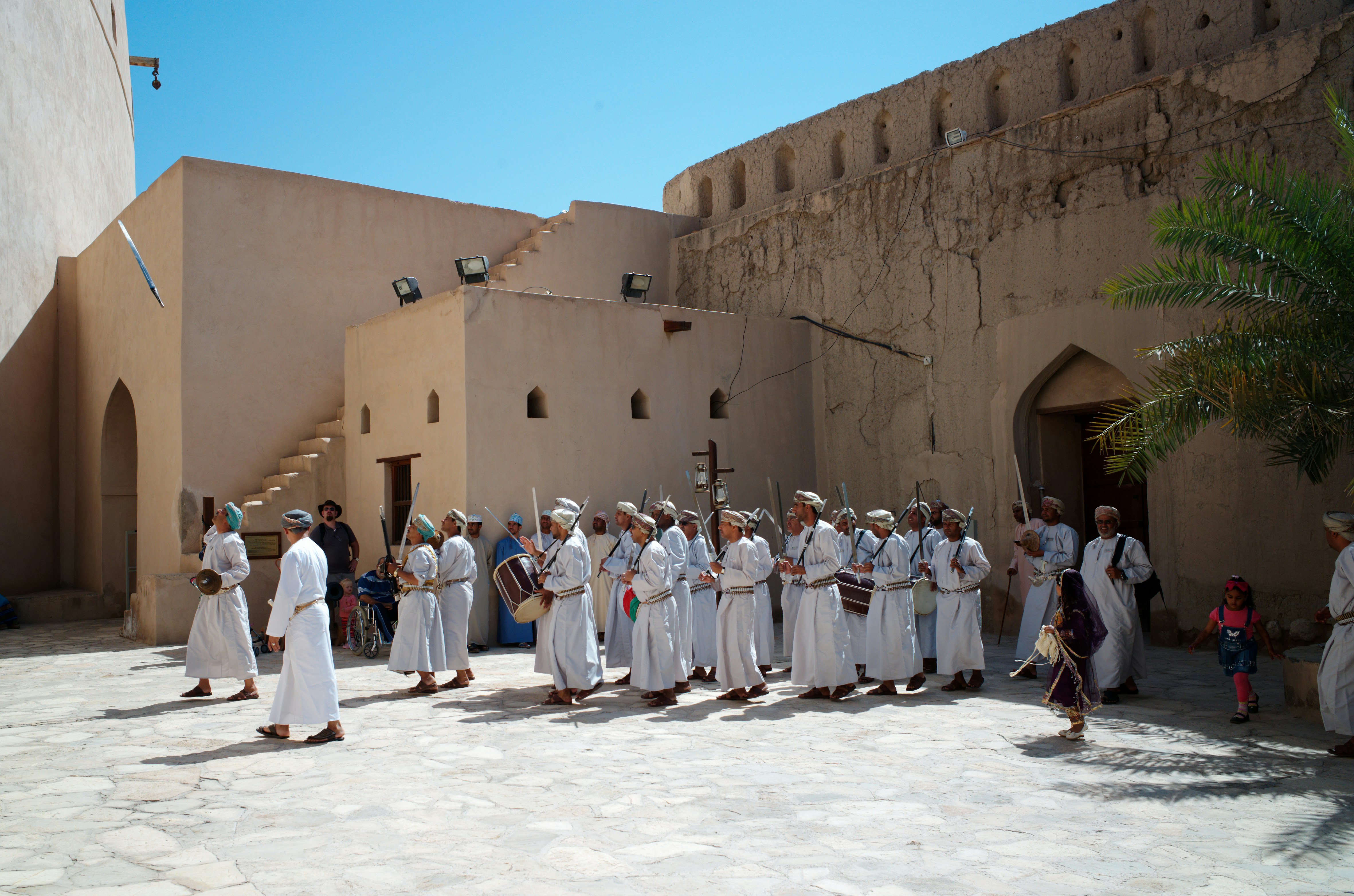 Ceremonial guards in traditional dress performing with swords in the courtyard of Nizwa Fort, Oman
