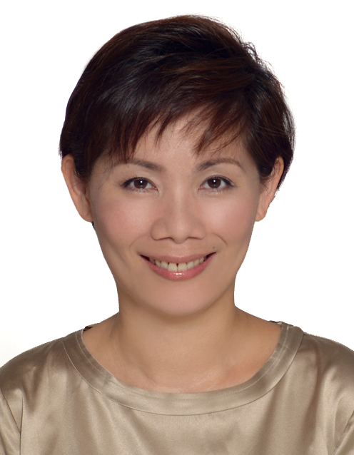 Portrait of a smiling woman with short dark hair wearing a shiny beige top against a white background.
