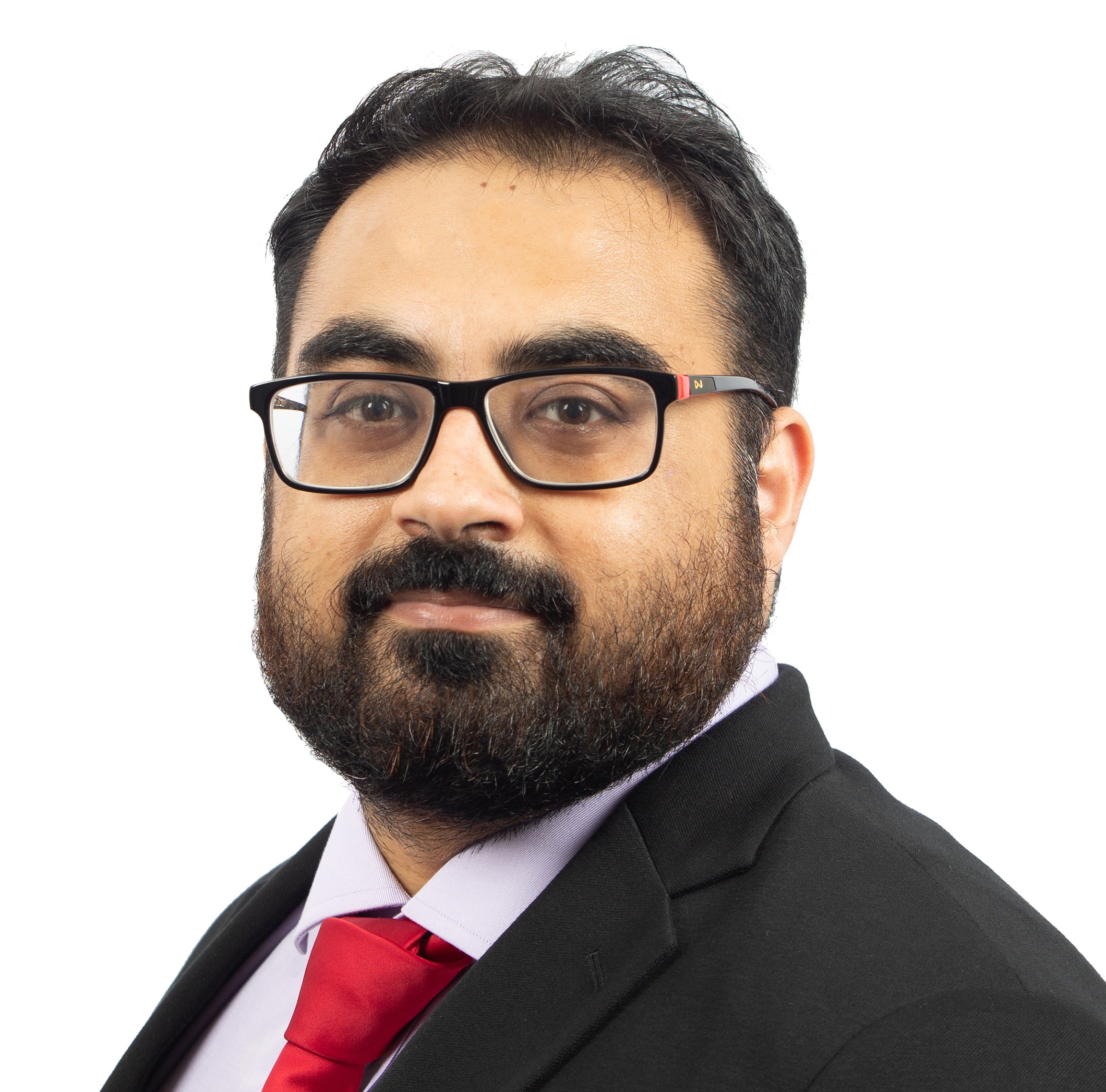 Man with black hair, beard, glasses, black suit, red tie, and light purple shirt against white background.