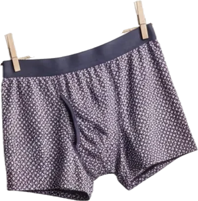 A pair of men's boxer shorts with a dark waistband and a small white geometric pattern on a dark fabric, hanging on a clothesline with two wooden clothespins.
