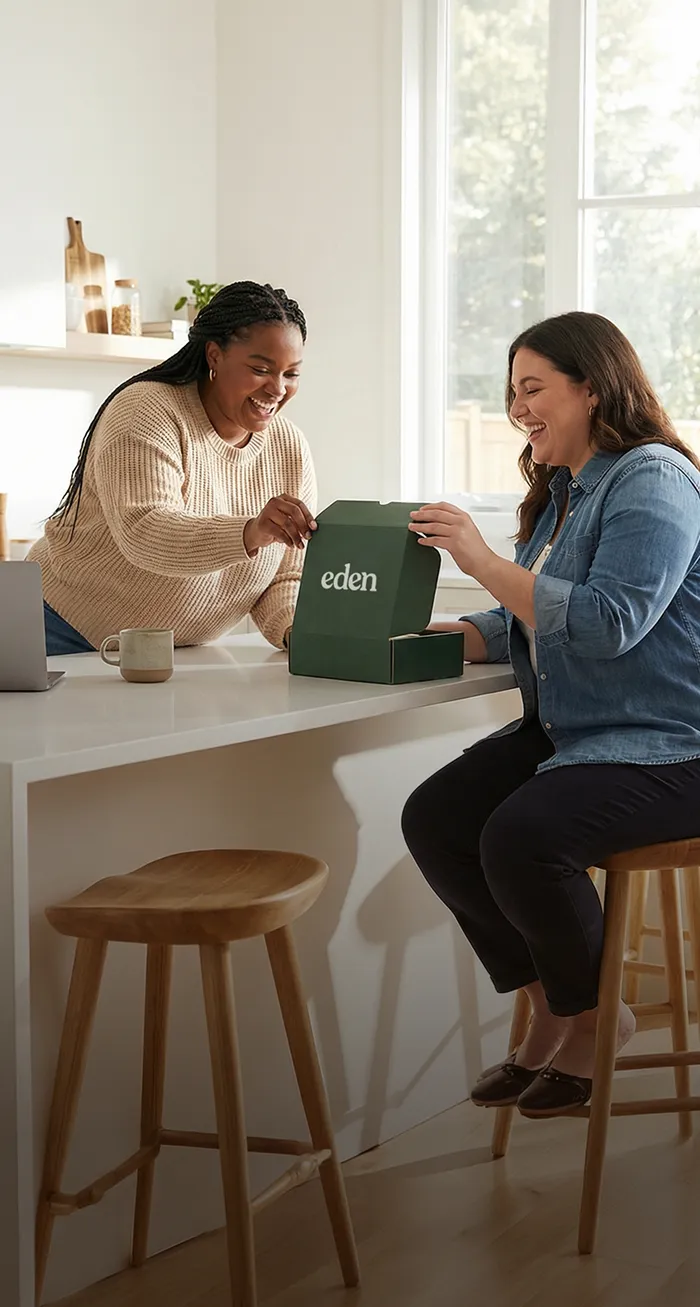 Two women in a kitchen happily talking over an Eden box