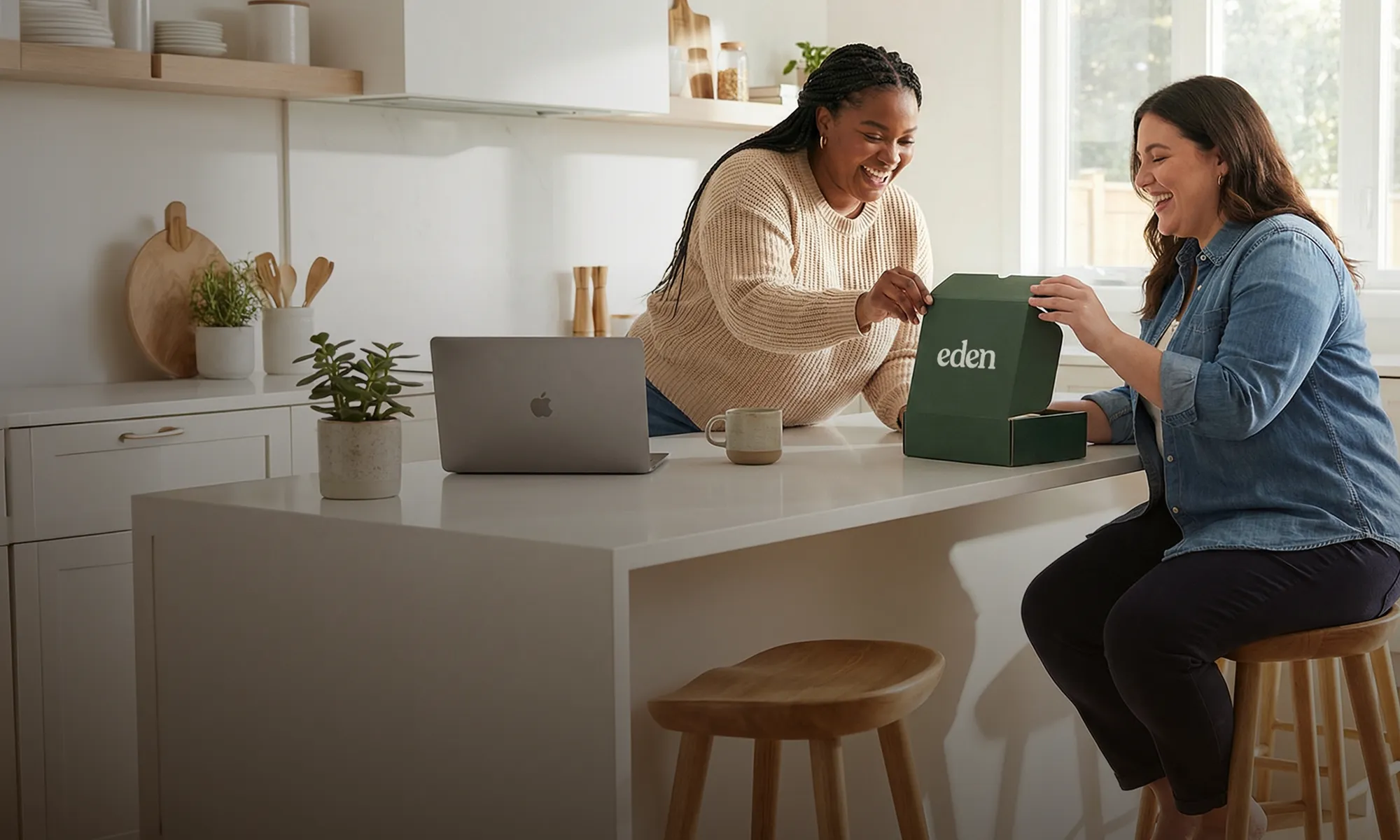 Two women in a kitchen happily talking over an Eden box