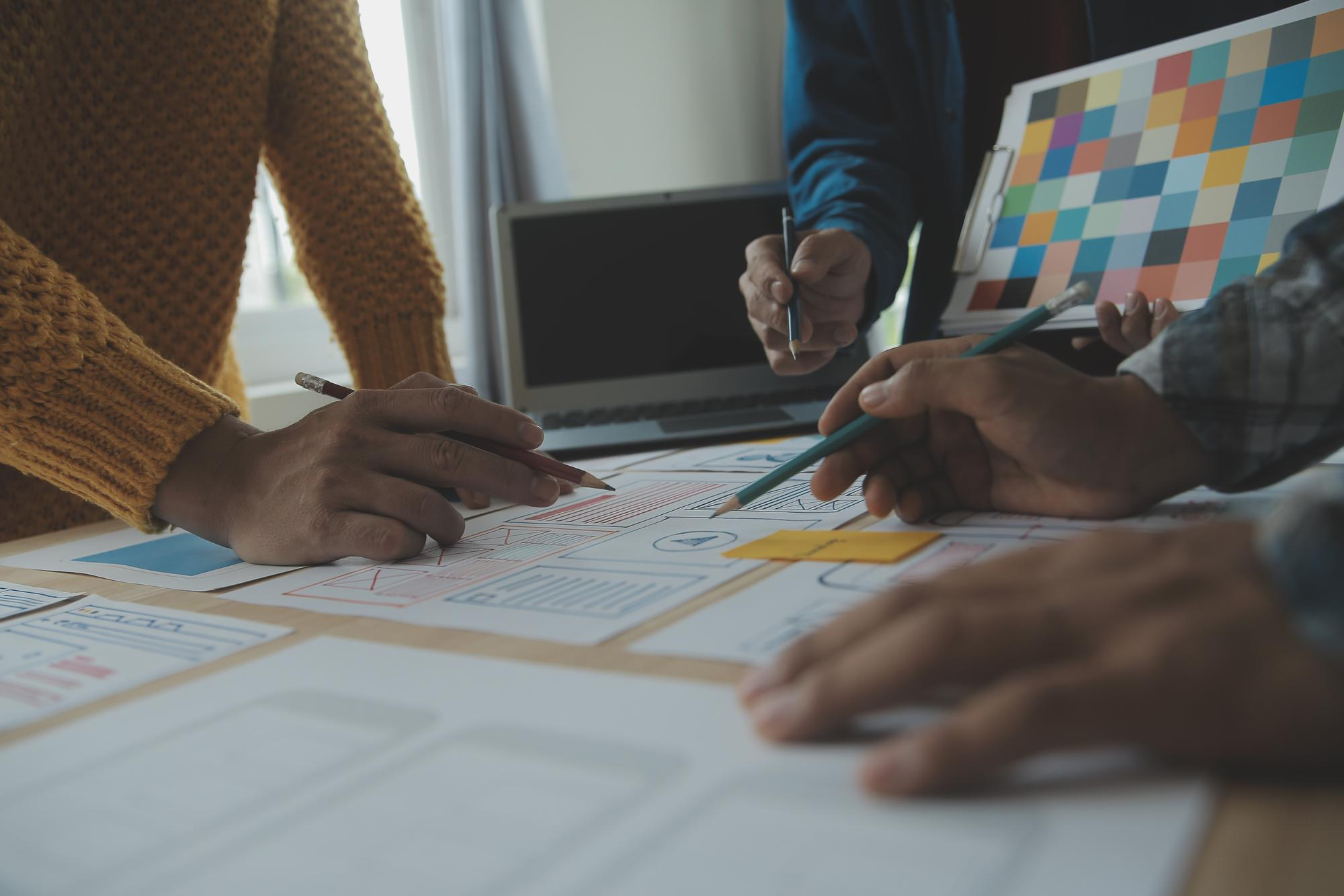 Team working at desk representing slow Webflow page development workflow