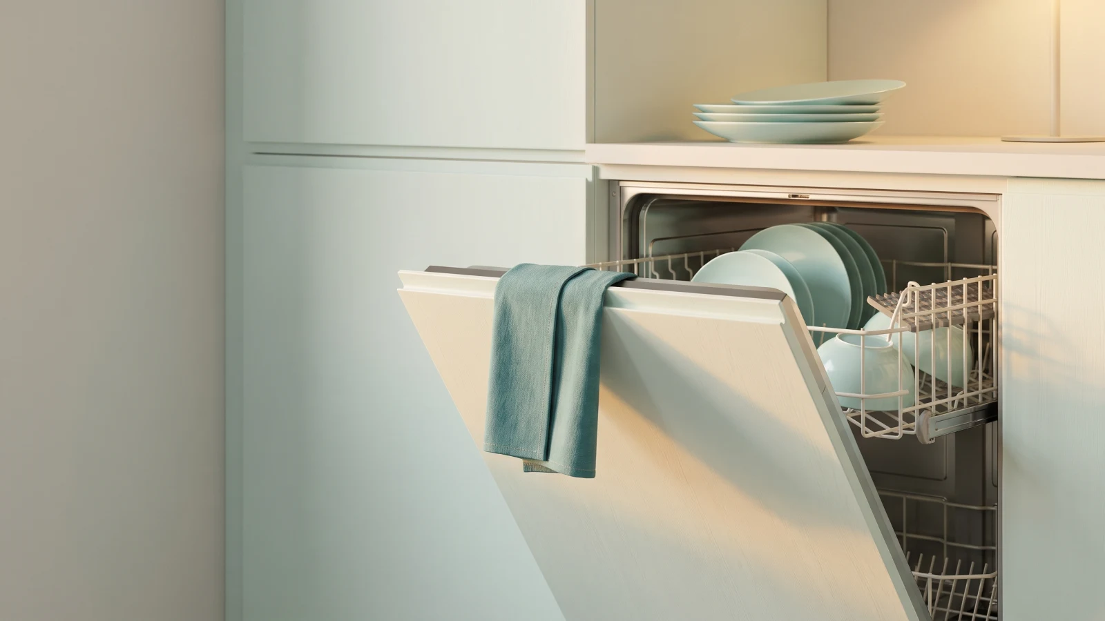 Half-open dishwasher with a teal towel over the door and a stack of plates still waiting on the counter