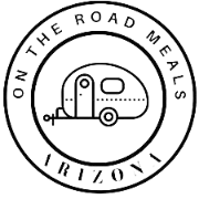 Round black and white stamp design with a small camper trailer in the center and text reading 'On the Road Meals Arizona' around the circle.