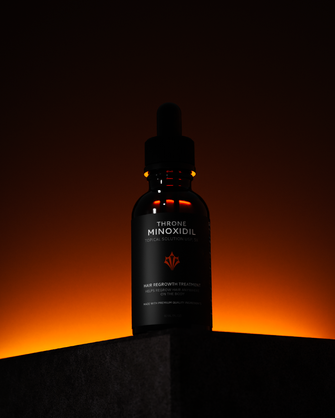 Bottle of Throne Minoxidil hair regrowth treatment with dropper on gray background.
