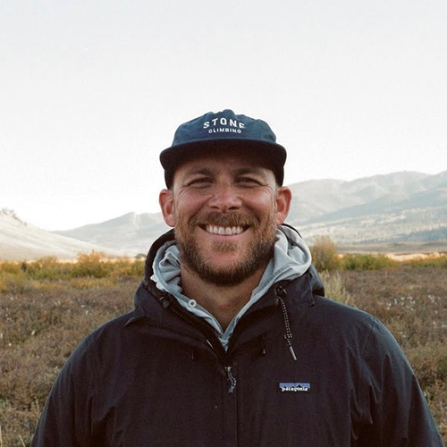 Ian Guthrie smiling in front of a beautiful mountain landscape.
